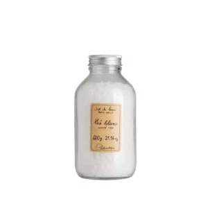 product photograph of Lothantique white tea bath salts. It comes in a clear bottle with a screw top lid.